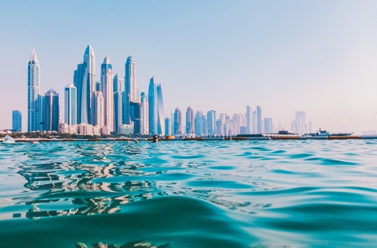 Mann schwimmt in Pool vor der Kulisse Dubais