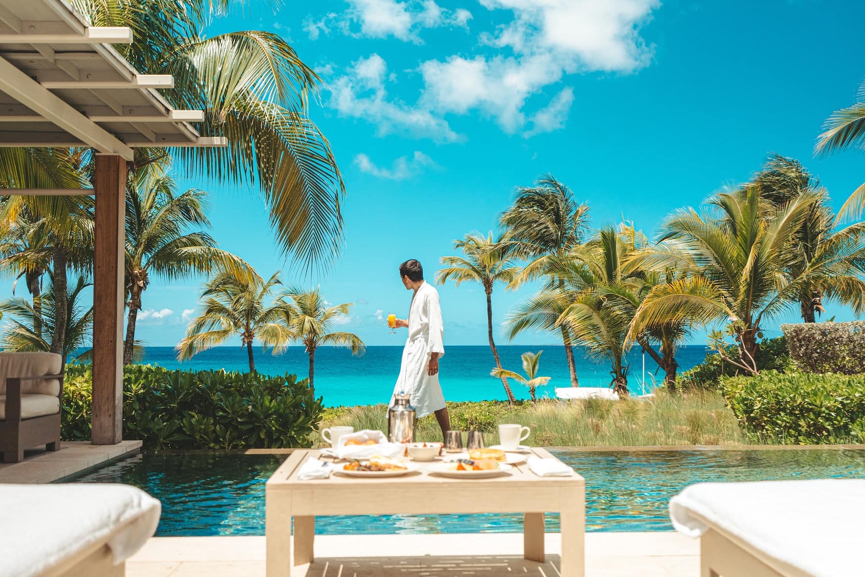 Mann in Bademantel spaziert durch karibisches Luxushotel