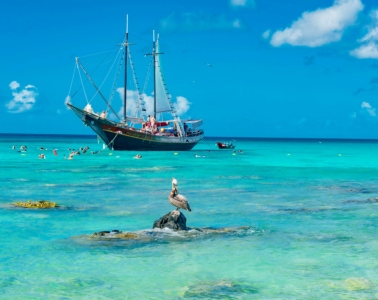 Türkisfarbenes Meer auf Aruba, Segelschiff im Hintergrund