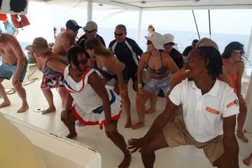 Einheimische und Touristen tanzen gemeinsam Merengue auf einem Boot an der Punta Cana