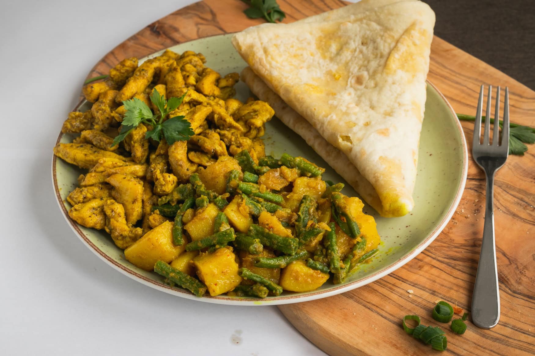 Roti mit Hähnchencurry, Kartoffeln und Kousenband, einem Gericht der hindustanischen Küche Surinames.