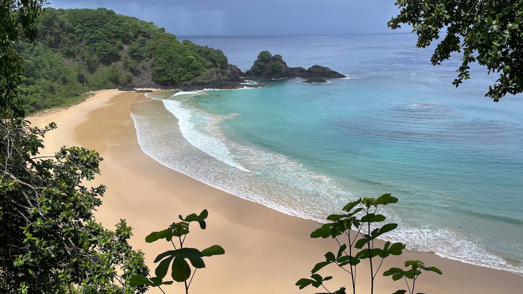 Blick vom Aussichtspunkt auf die Baía do Sancho mit hellem Sandstrand und türkisfarbenem Wasser auf Fernando de Noronha, Brasilien.