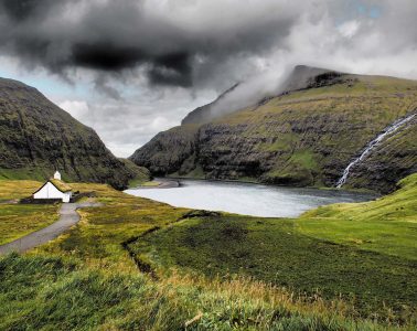 Bucht mit Wasserfall und Kirche auf den Färöern