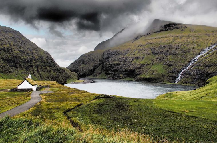 Bucht mit Wasserfall und Kirche auf den Färöern