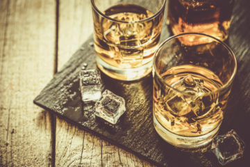 Whiskey-Gläser auf schwarzem Tablett, Foto im Retro-Style