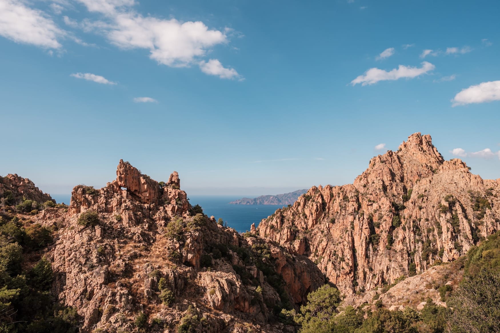 Die dramatischen Felsformationen der Calanches de Piana auf Korsika mit dem Mittelmeer in der Ferne
