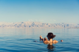 Frau schwimmt auf Wasseroberfläche auf dem Toten Meer in Jordanien
