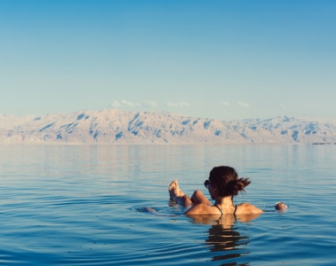 Frau schwimmt auf Wasseroberfläche auf dem Toten Meer in Jordanien
