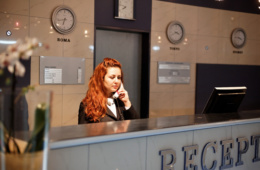 Telefonierende Frau an Rezeption in Hotel