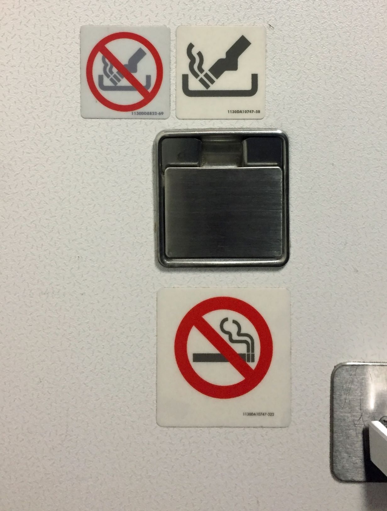 Zigaretten-Symbolzeichen auf Toilette im Flugzeug 