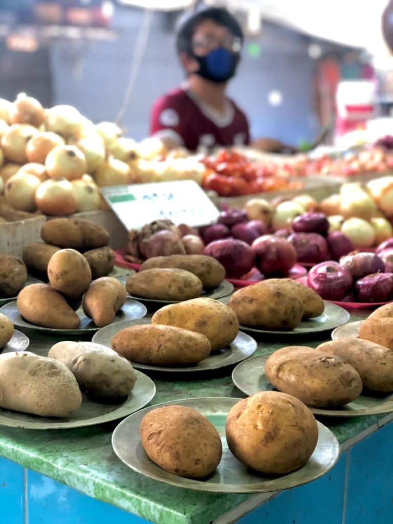 Marktverkäuferin mit Kartoffeln