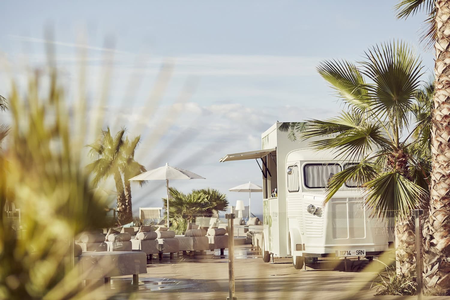 Außenbereich in einem Resort, mit Palmen und einem Foodtruck