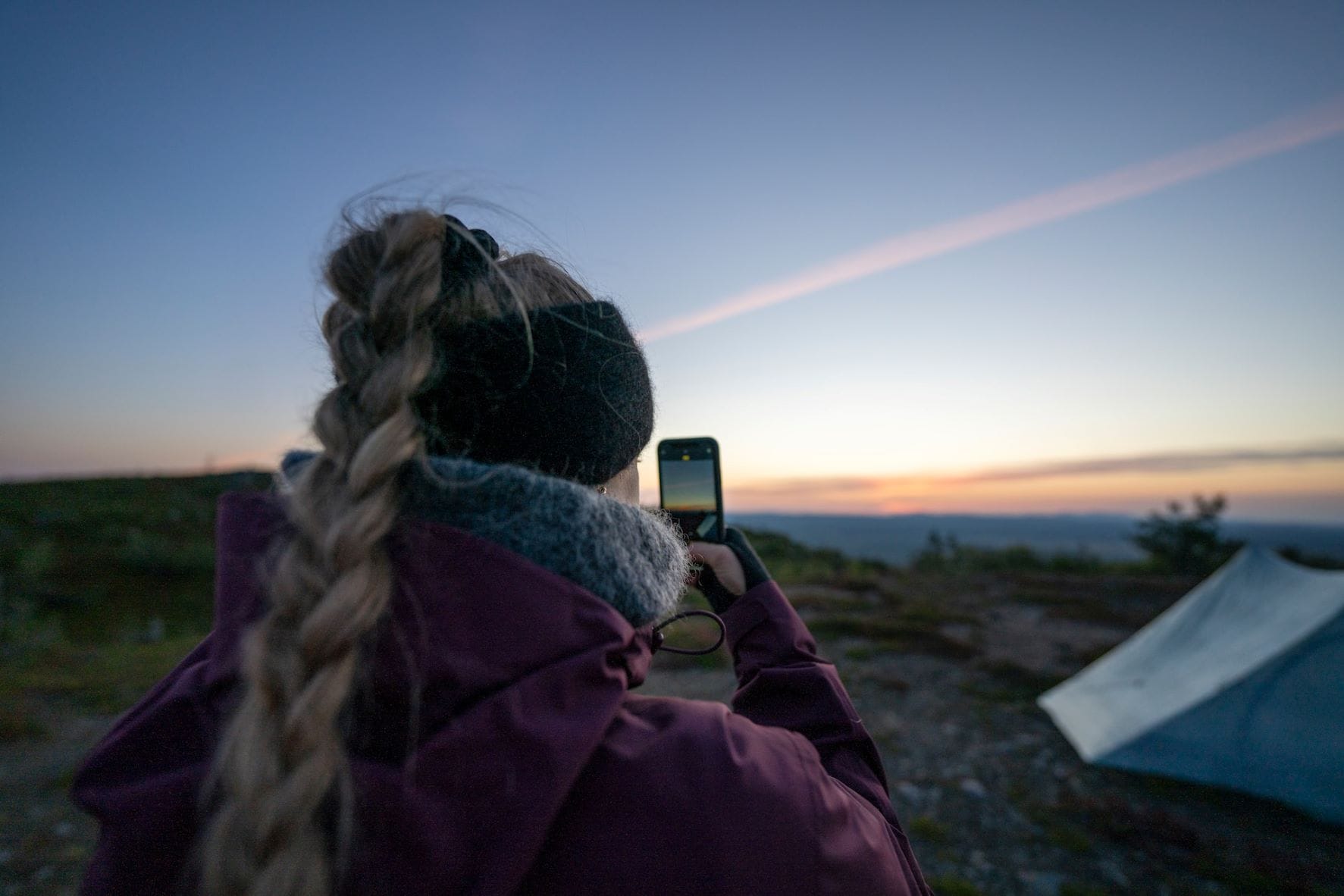 Frau macht Foto von Zelt und Meer in Finnland 