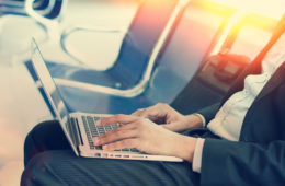 US-Laptop-Verbot: Geschäftsmann mit Laptop auf dem Schoß im Flughafen