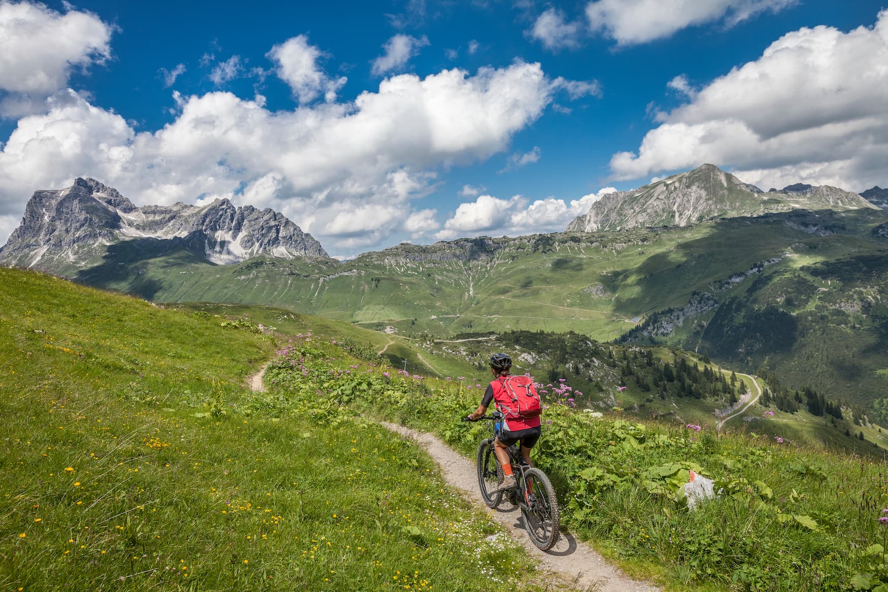 Frau fährt mit dem E-Bike durch die österreichischen Alpen