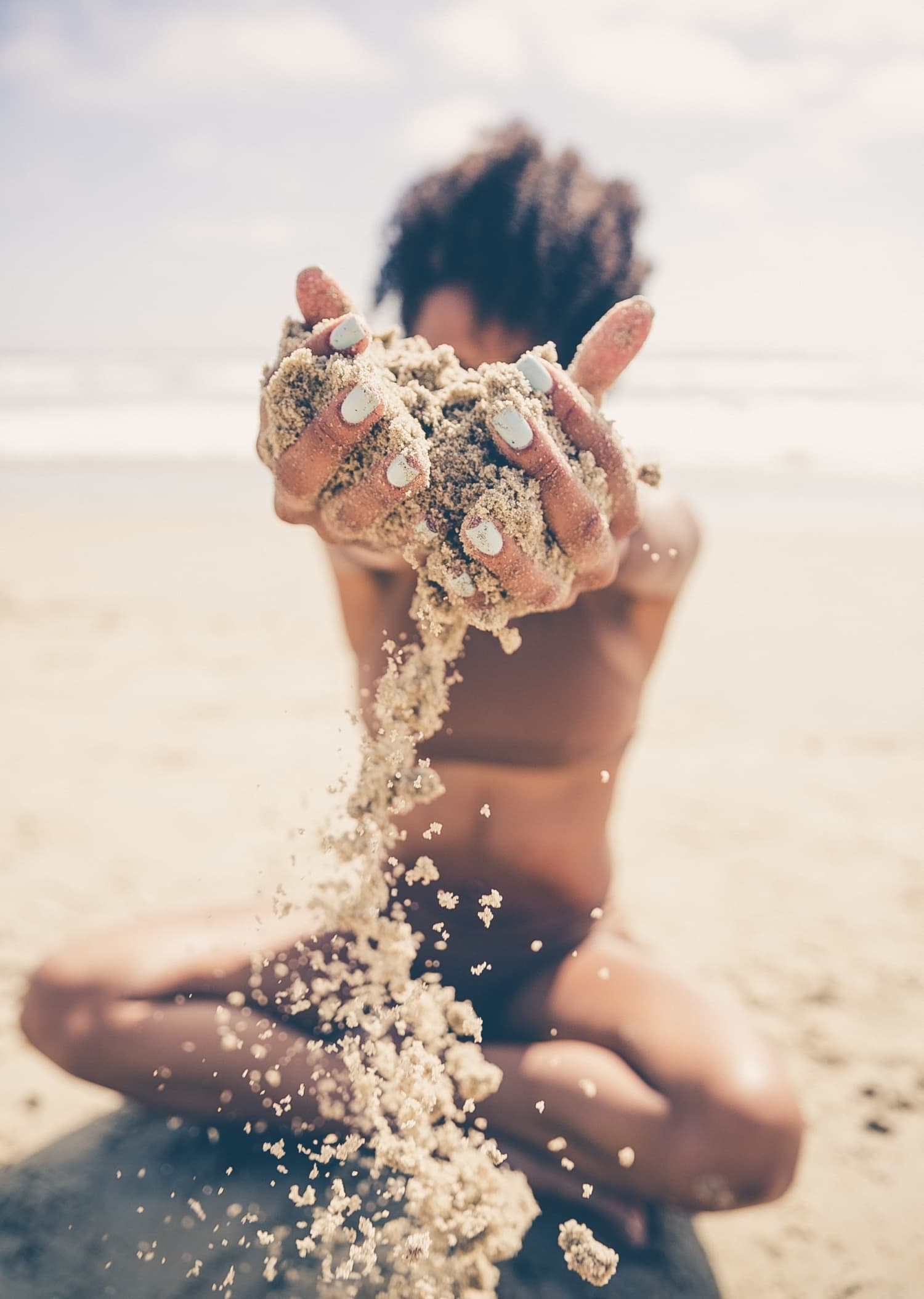 Kind spielt mit Sand an Strand