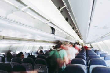 menschen gehen durch Reihen im Flugzeug auf der suche nach dem besten Sitzplatz