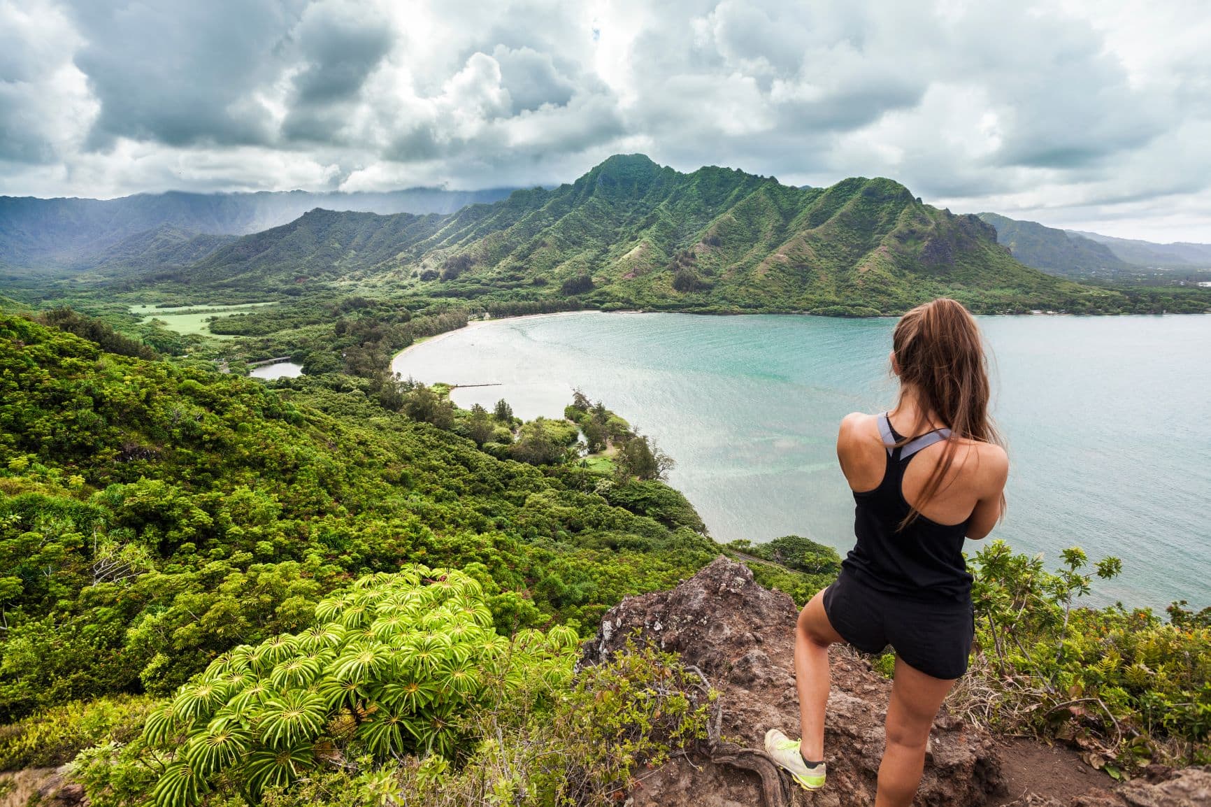Sportliche junge Frau blickt auf Natur auf Hawaii 