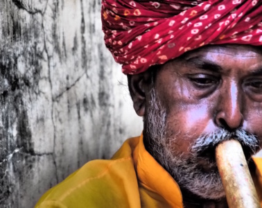 Mann mit Turban spielt Flöte in Rajasthan