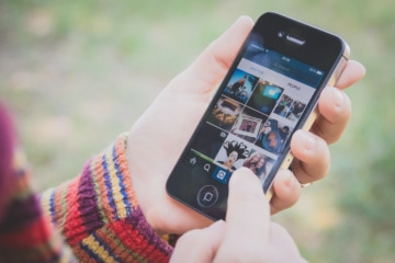 Populäre Hashtags: Person mit Handy in der Hand, Instagram-App geöffnet
