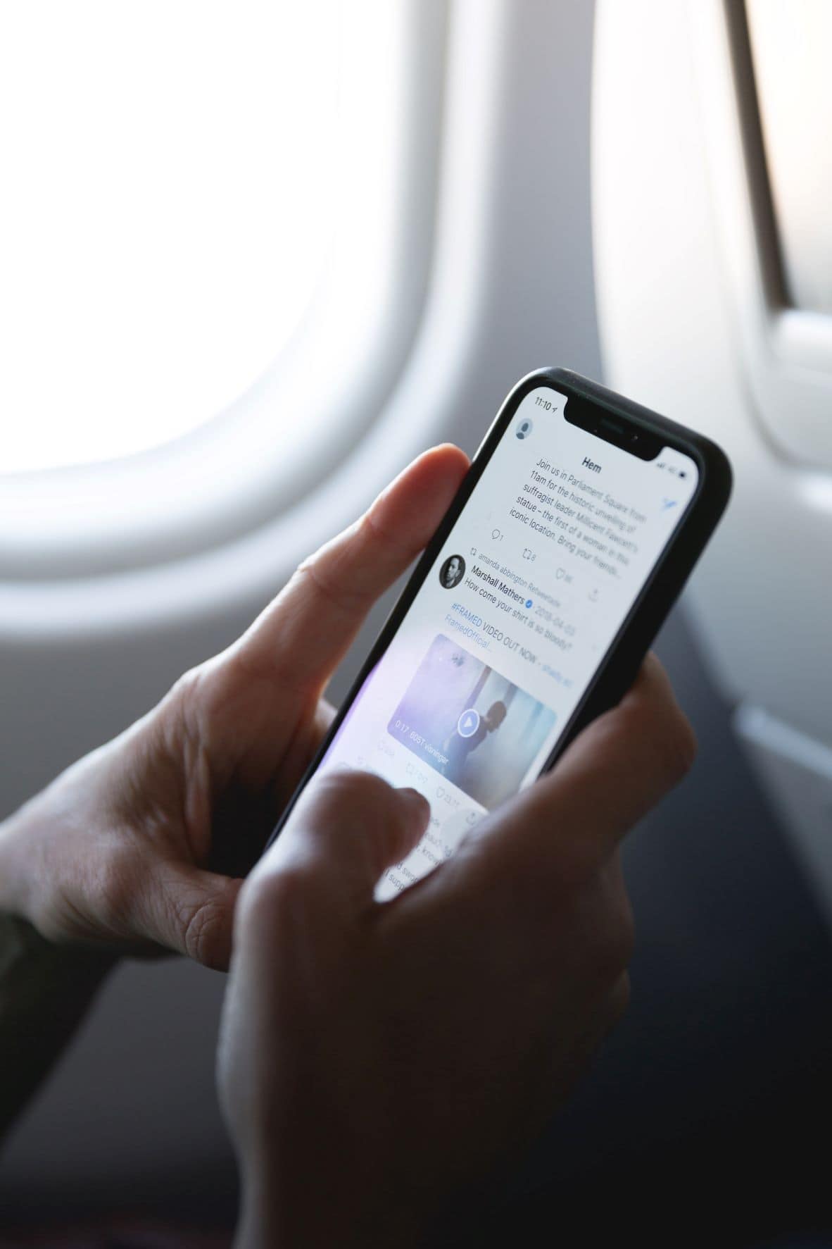 Person surft mit Handy im Flugzeug 