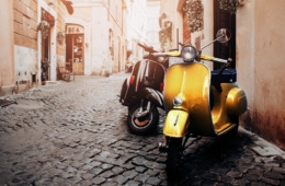 Gelbe Vespa steht in einer Seitenstraße in Rom