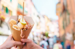 Streetfood in Italien – gegrillte Kalamari, Schrimps und Gemüse in einer Tüte.