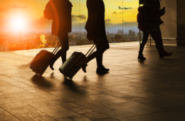 Passagiere mit Koffer im Schlepptau im Flughafen
