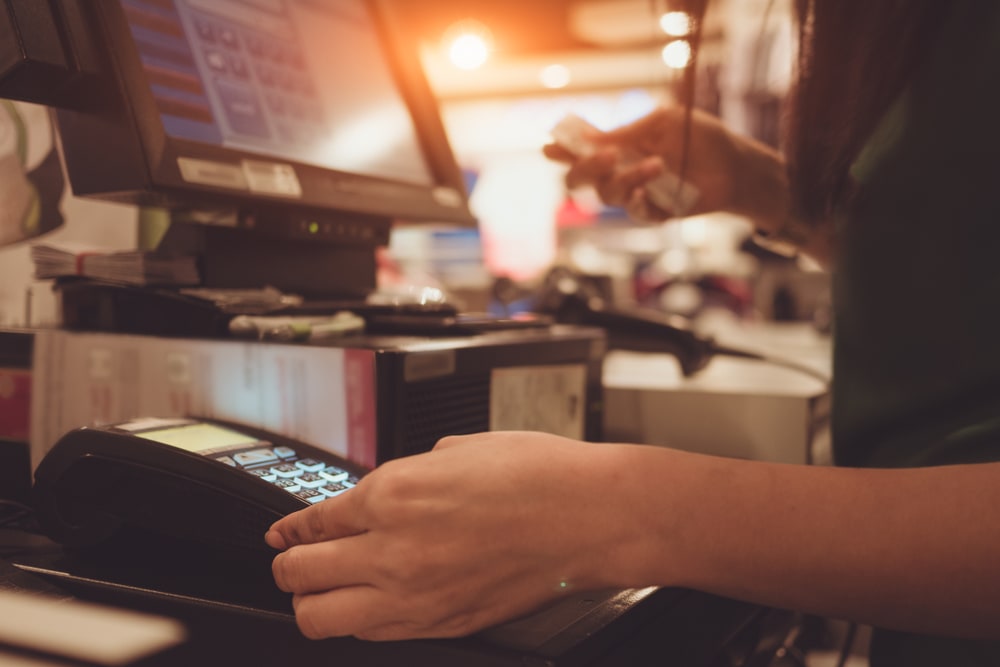 Verkäuferin mit Kreditkarte in der Hand