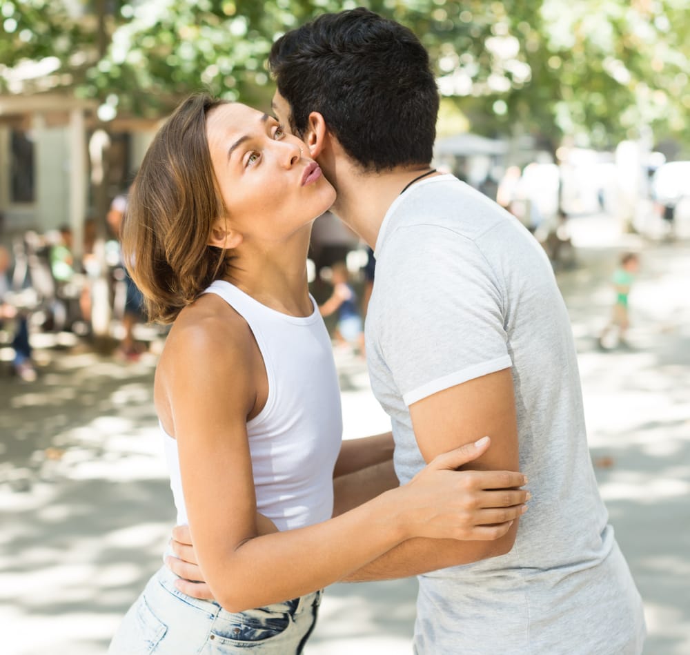 Mann und Frau küssen sich zur Begrüßung