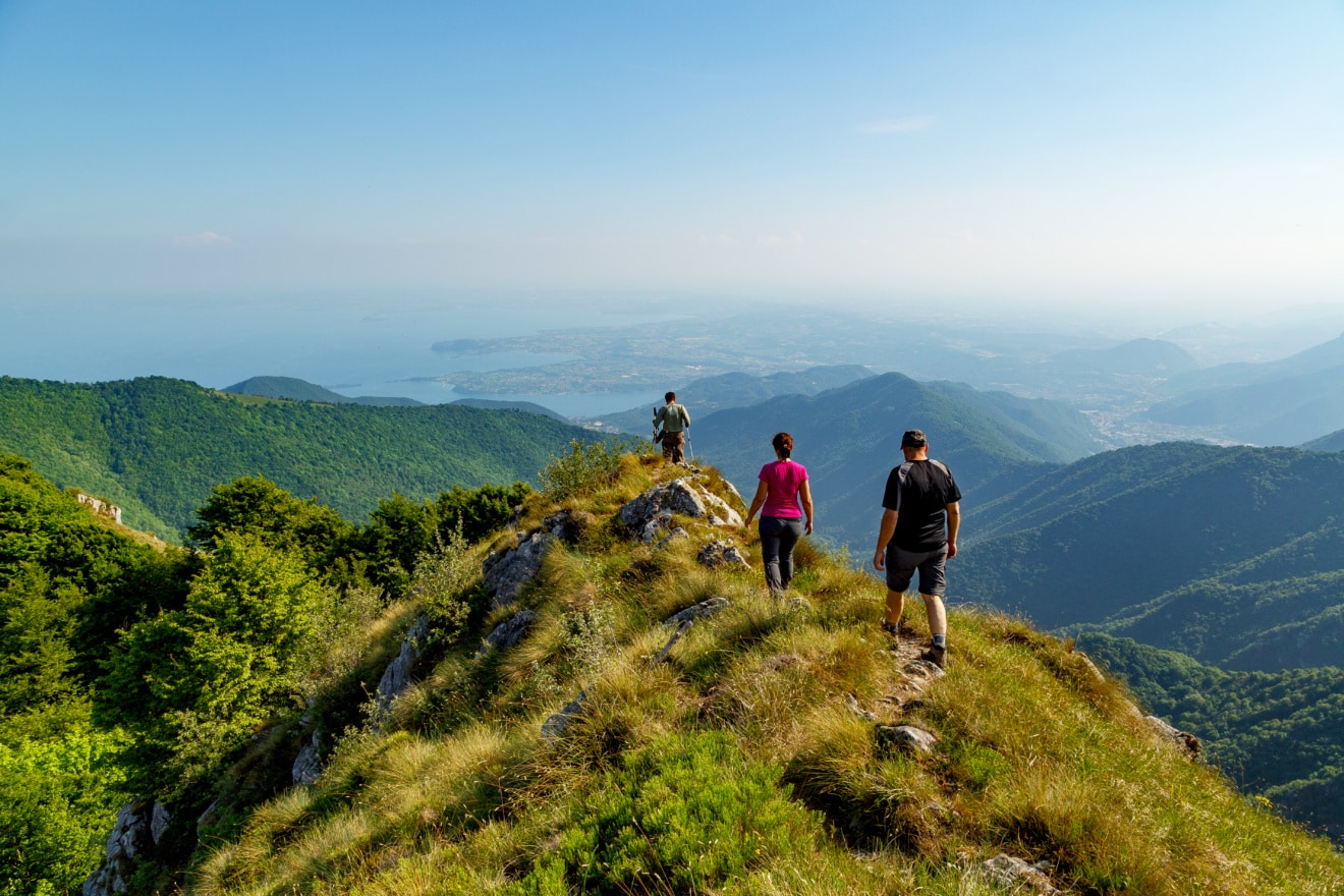 Drei Wanderer auf Bergkamm mit Panorama