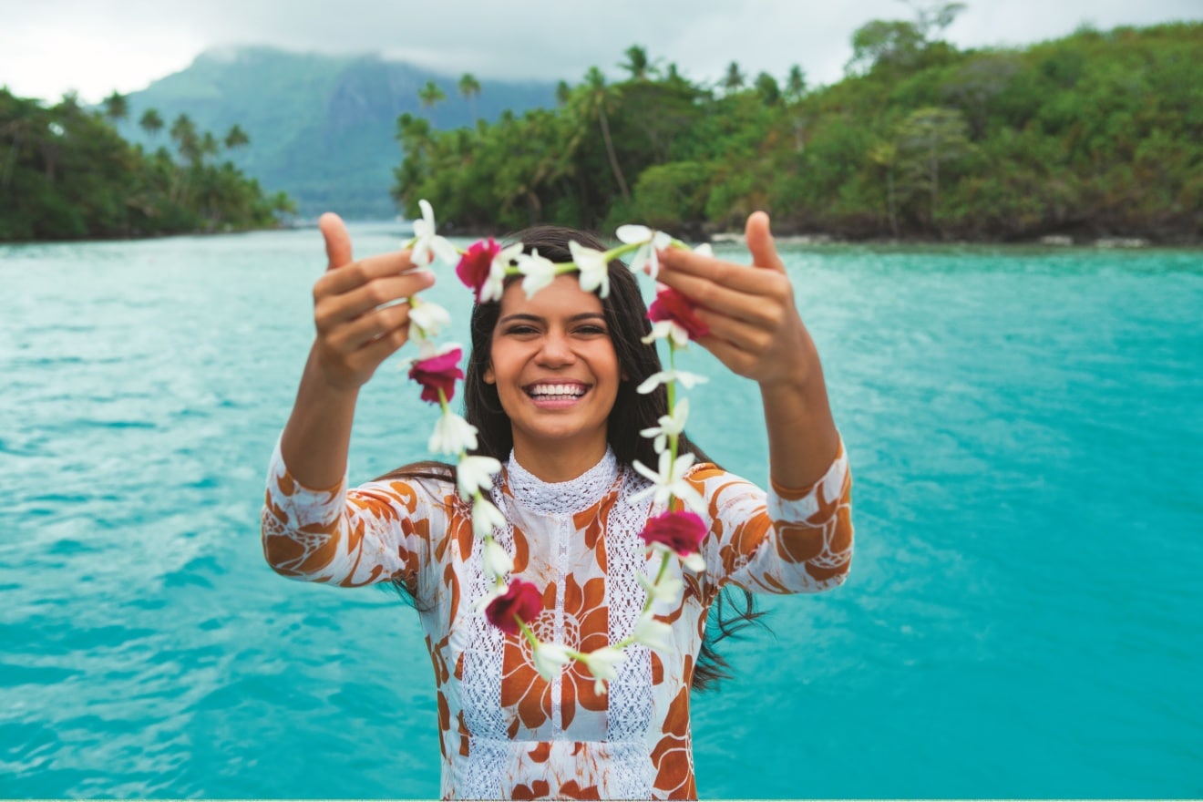 Frau mit Blumenkette vor einem See, Wilkommen in Tahiti