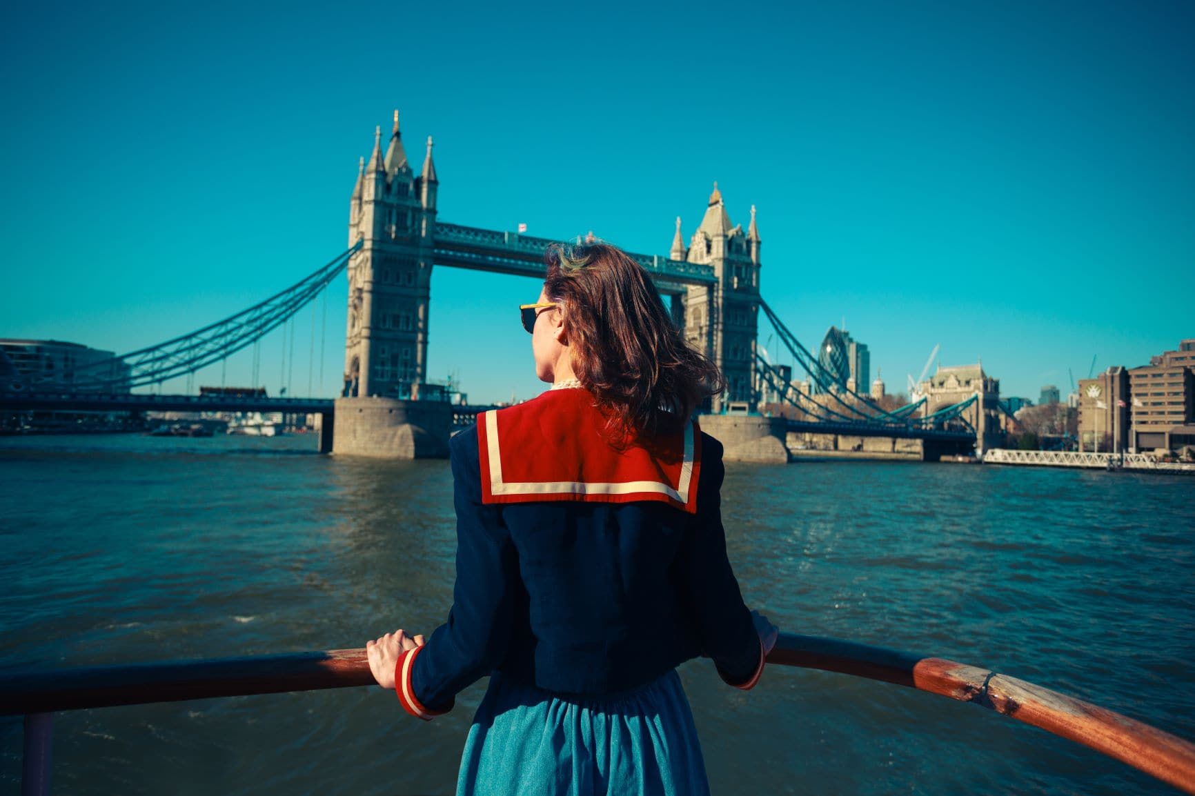 Frau an der Reeling eines Ausflugsbootes auf der Themse in London