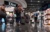 Passagiere laufen am Dior-Shop im Flughafen London vorbei