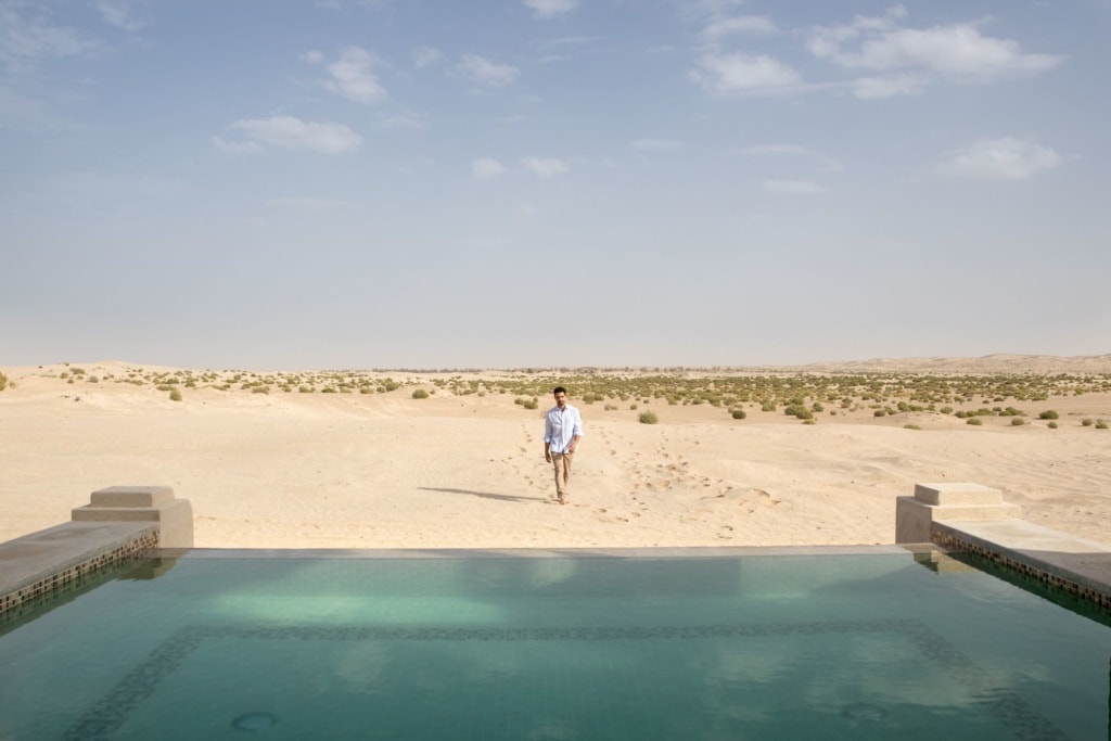 Mann hinter Pool im Jumeirah Al Wathba Desert Resort