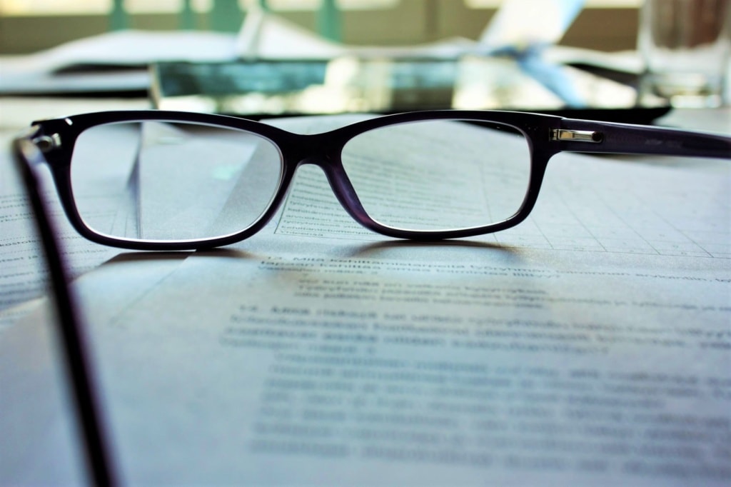 Brille auf bedruckten Blättern liegend