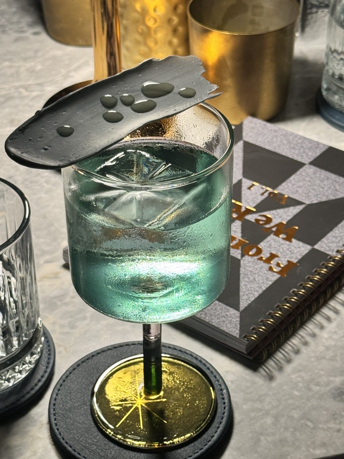 Türkisfarbener Cocktail in der Bar Under The Stairs im Corinthia Grand Hotel Astoria in Brüssel