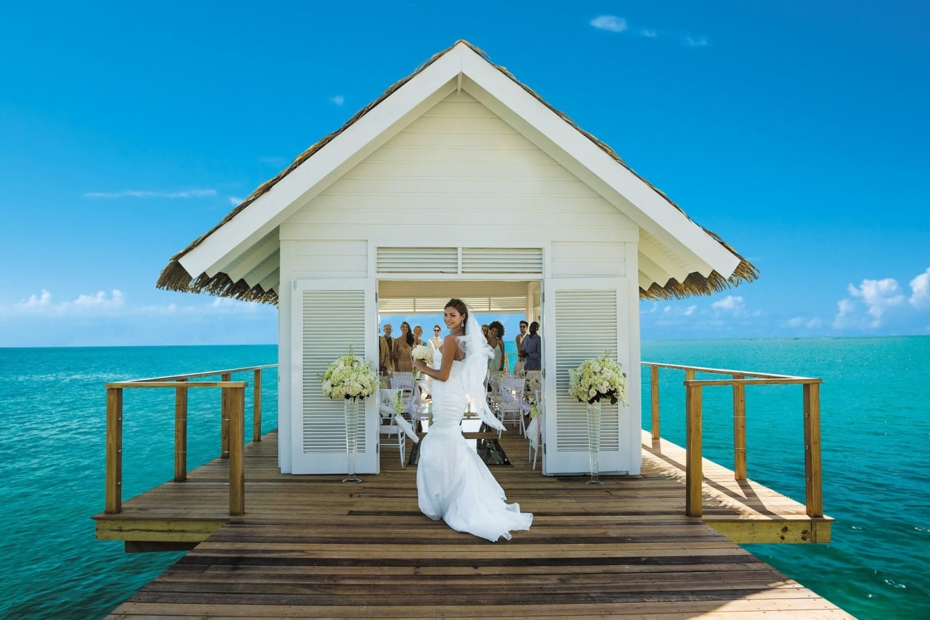 Braut vor Hochzeitsgäste auf Steg in der Karibik