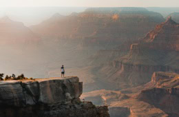 Mann steht am Grand Canyon