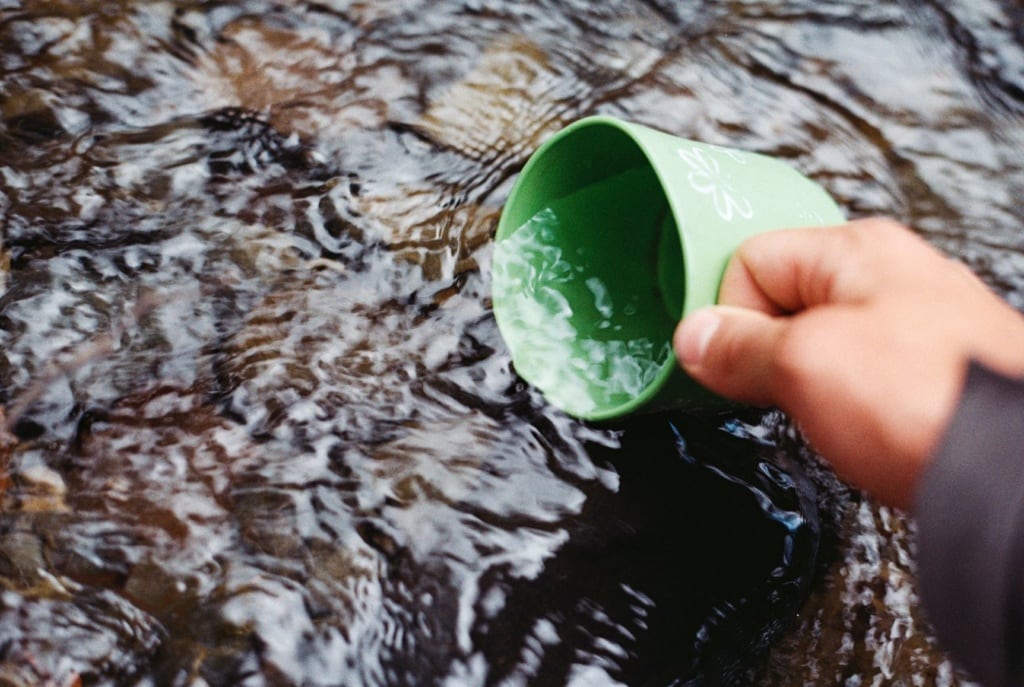 Grüne Tasse im Bach
