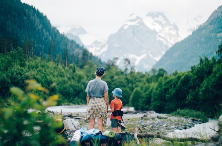 Vater und Sohn beim Wandern vor Gebirgskette