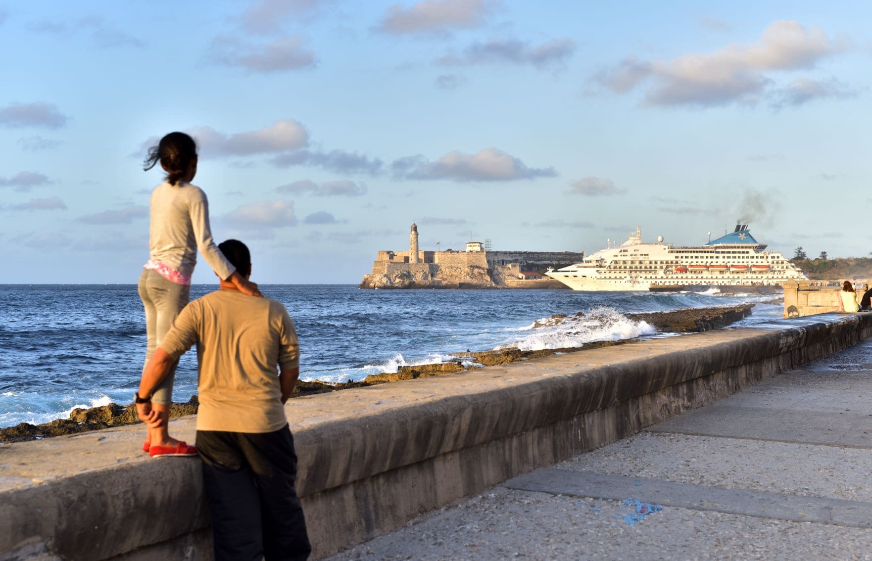 Vater und Tochter beobachten am Malecron in Havanna das Auslaufen eines Kreuzfahrtschiffes