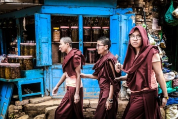 junge männer laufen straße entlang eines shops in kathmandu