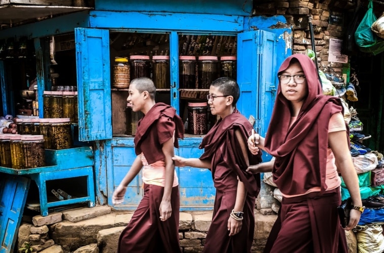 junge männer laufen straße entlang eines shops in kathmandu
