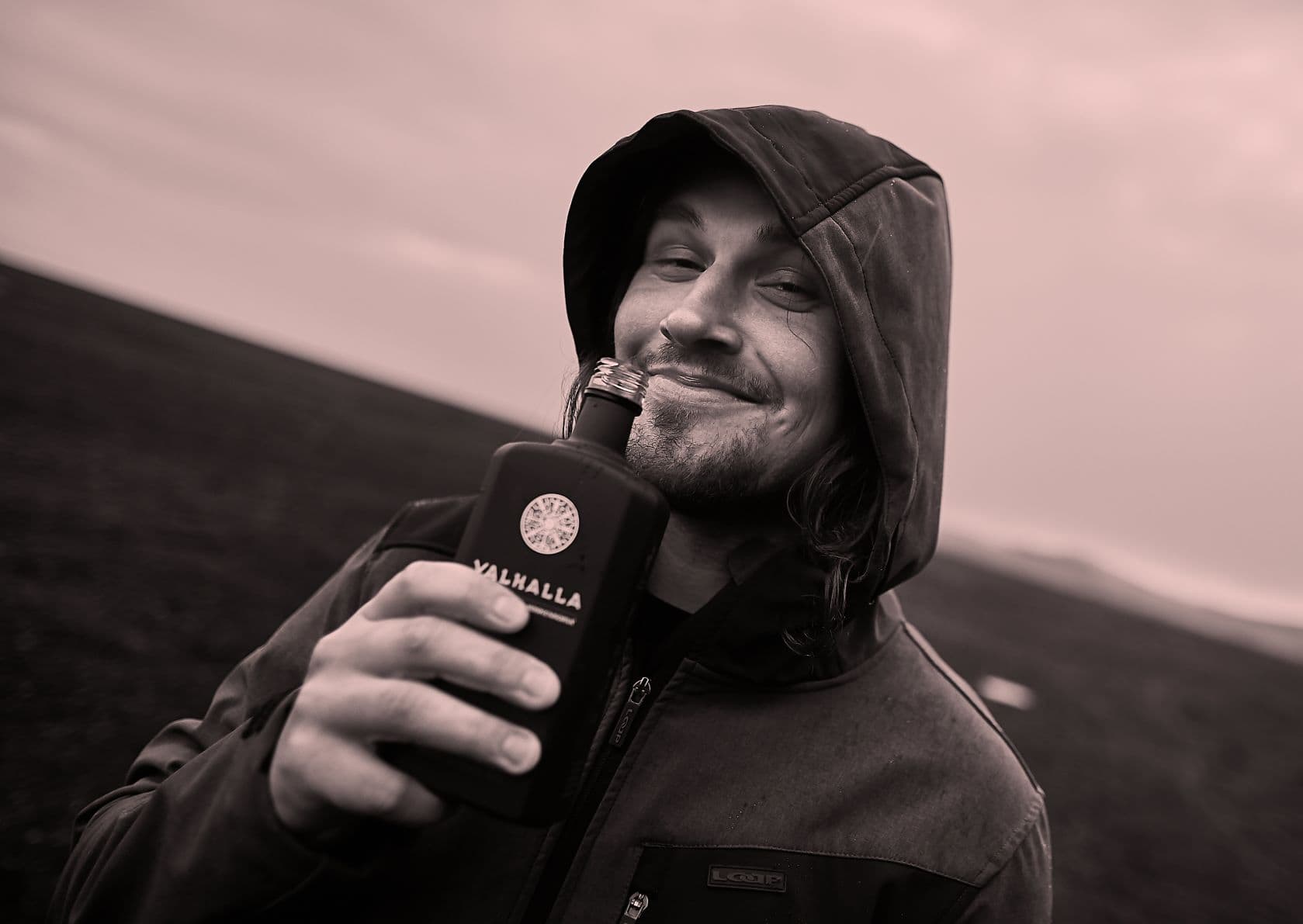 Mann hält Flasche Likör vors Gesicht