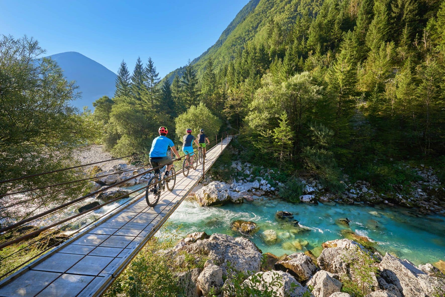 Radfahrer überqueren eine Brücke im Soca-Tal in Slowenien 