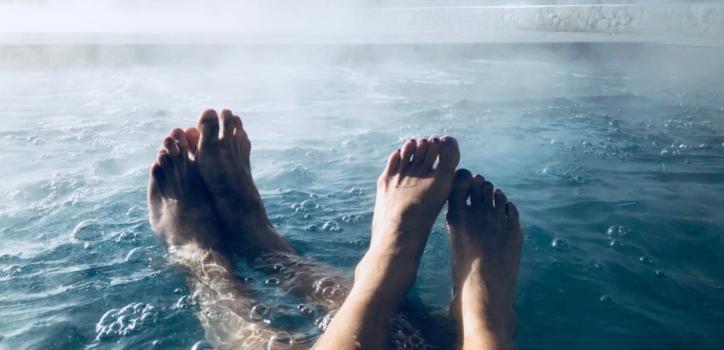 Füße von Mann und Frau in heißem Wasser