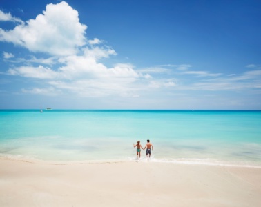 Paar auf Antigua läuft vom Strand ins Meer