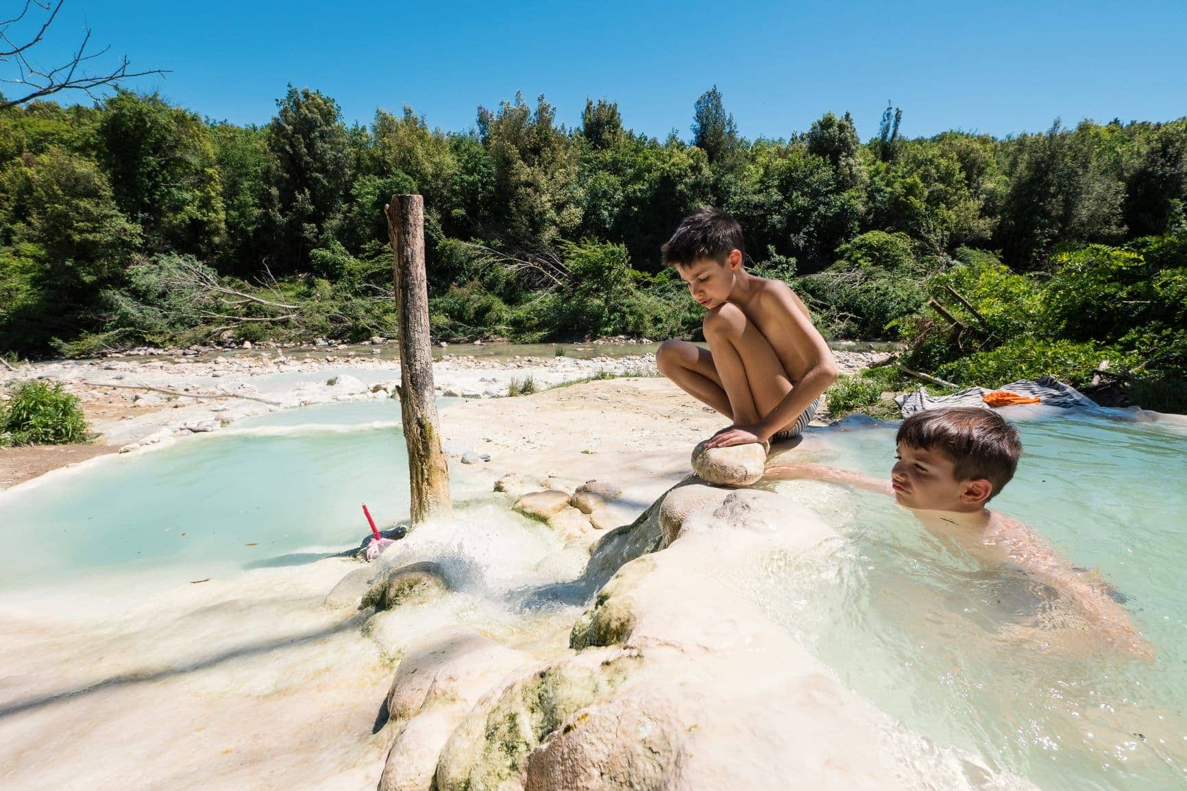 Zwei Jungen baden in der Therme Bagni di Petriolo in der Toskana