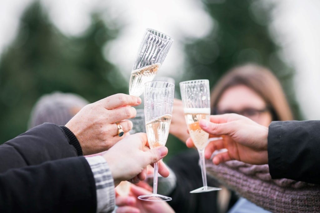 Mehrere Personen stoßen mit Gläsern Champagner an